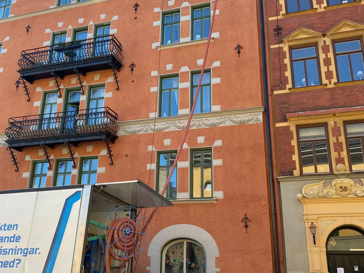 Ekovillas lastbil framför ett tegelhus i flerbostadsområde