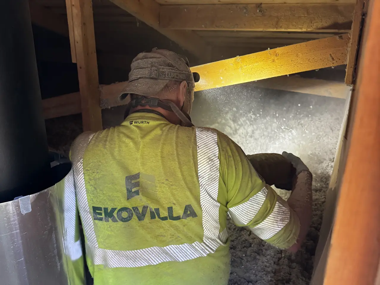 Installatör med isoleringsslang vid vindslucka